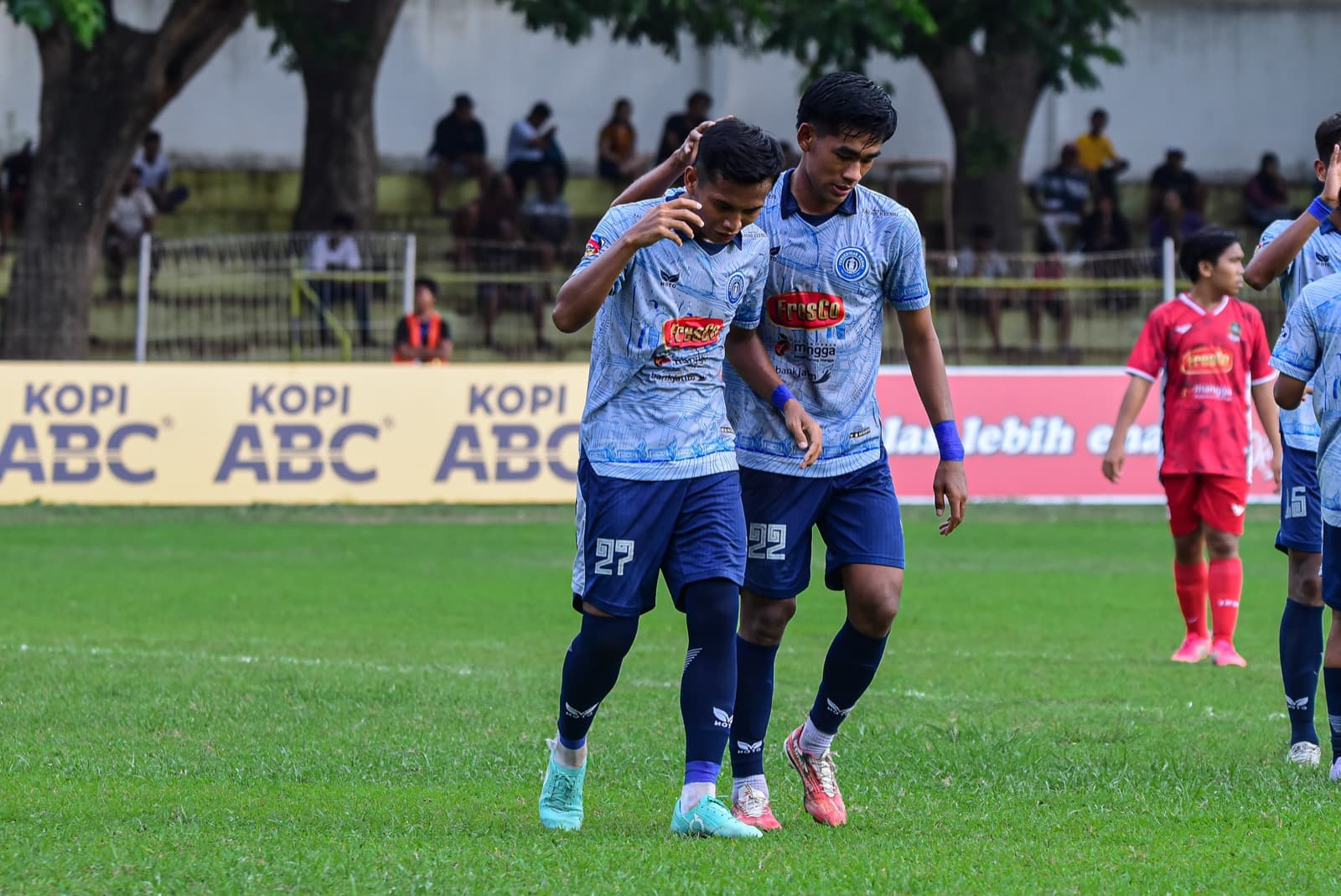 Two Persedikab players walking off the pitch after a goal
